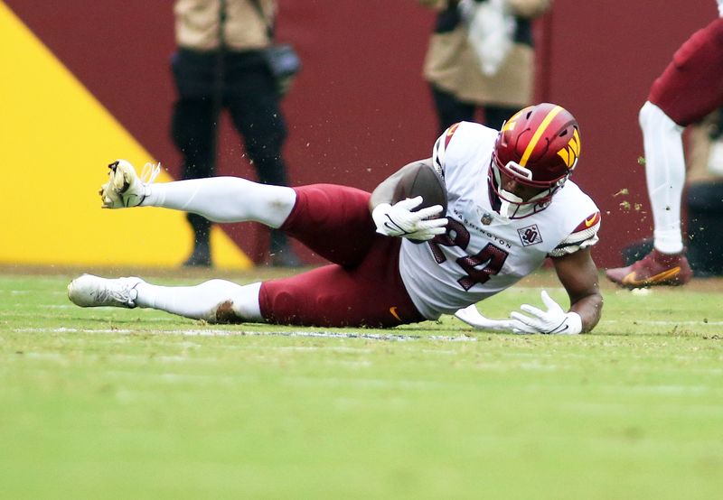 Washington Commanders running back Antonio Gibson (24) makes a diving catch during an NFL football game against the Jacksonville Jaguars, Sunday, Sept. 11, 2022 in Landover. (AP Photo/Daniel Kucin Jr.)