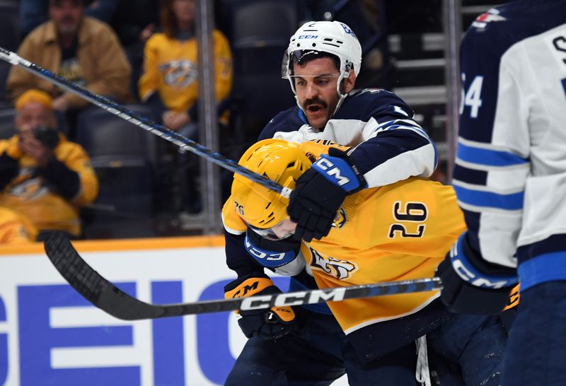 Nov 26, 2023; Nashville, Tennessee, USA; Nashville Predators center Philip Tomasino (26) is grabbed by Winnipeg Jets defenseman Dylan DeMelo (2) during the third period at Bridgestone Arena. Mandatory Credit: Christopher Hanewinckel-USA TODAY Sports