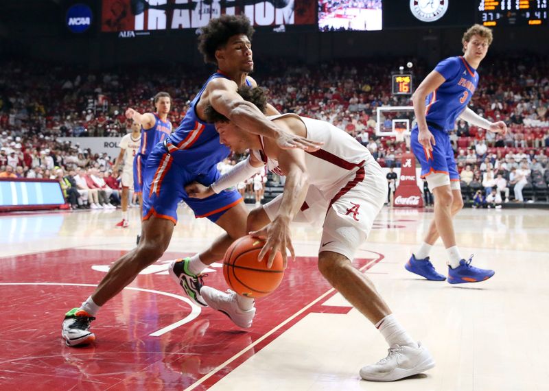 Feb 21, 2024; Tuscaloosa, Alabama, USA; Florida Gators forward Zyon Pullin (0) fouls Alabama Crimson Tide guard Mark Sears (1) as he drives into the lane at Coleman Coliseum. Alabama came from behind to defeat Florida 98-93 in overtime. Mandatory Credit: Gary Cosby Jr.-USA TODAY Sports