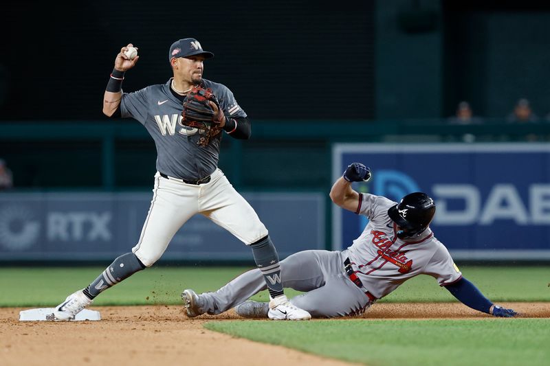 Jun 7, 2024; Washington, District of Columbia, USA; Washington Nationals second baseman Ildemaro Vargas (14) turns a double play at second base ahead of a slide by Atlanta Braves left fielder Adam Duvall (14) during the ninth inning at Nationals Park. Mandatory Credit: Geoff Burke-USA TODAY Sports