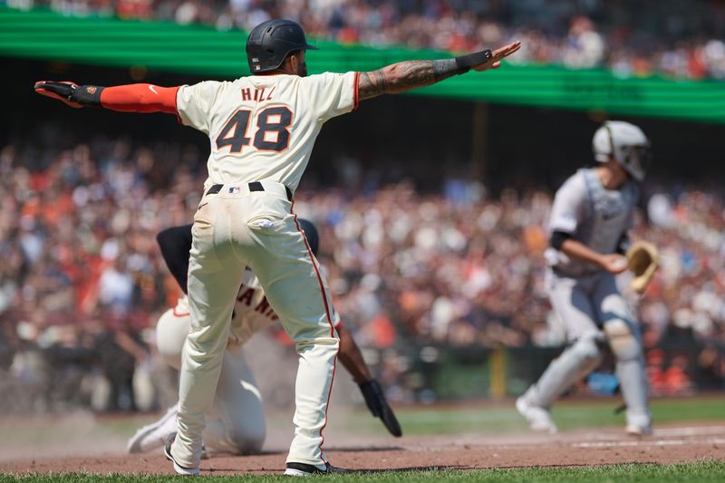 Jul 28, 2024; San Francisco, California, USA; San Francisco Giants outfielder Derek Hill (48) makes the safe sign after designated hitter Jorge Soler (2) slides into home to score a run against the Colorado Rockies during the sixth inning at Oracle Park. Mandatory Credit: Robert Edwards-USA TODAY Sports