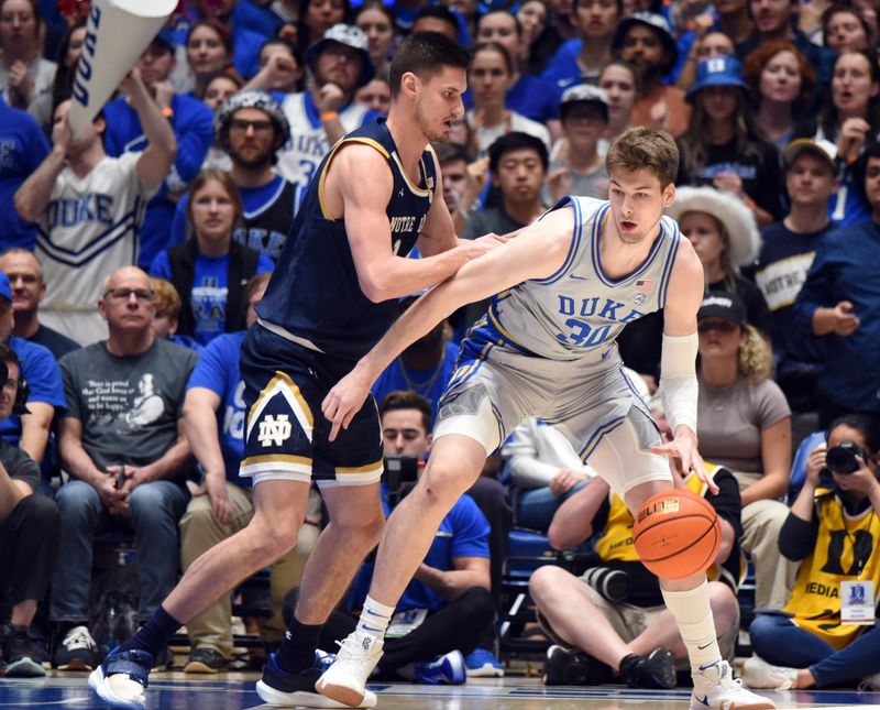 Feb 14, 2023; Durham, North Carolina, USA;  Duke Blue Devils center Kyle Filipowski(30) controls the ball in front of Notre Dame Fighting Irish forward Nate Laszewski (14) during the first half at Cameron Indoor Stadium. Mandatory Credit: Rob Kinnan-USA TODAY Sports