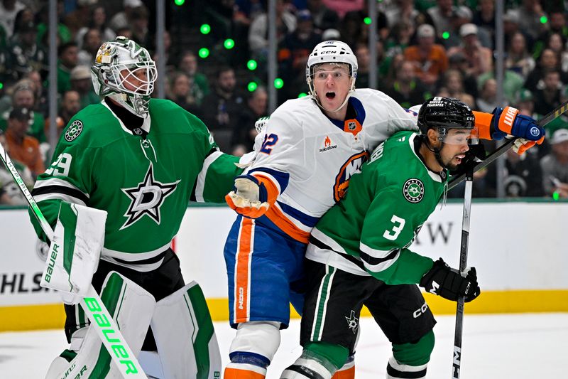 Oct 12, 2024; Dallas, Texas, USA; New York Islanders center Kyle MacLean (32) skates between Dallas Stars goaltender Jake Oettinger (29) and defenseman Matt Dumba (3) during the first period at the American Airlines Center. Mandatory Credit: Jerome Miron-Imagn Images