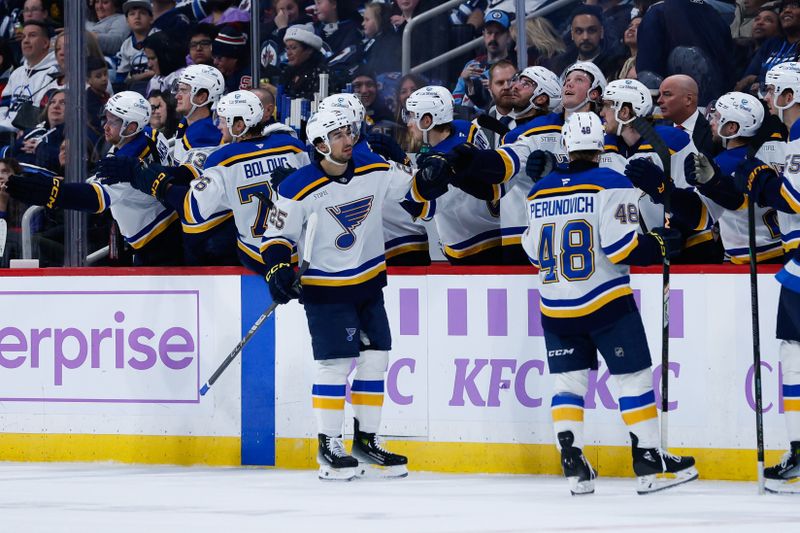 Dec 3, 2024; Winnipeg, Manitoba, CAN;  St. Louis Blues forward Jordan Kyrou (25) is congratulated by his teammates on his goal against the Winnipeg Jets during the second period at Canada Life Centre. Mandatory Credit: Terrence Lee-Imagn Images