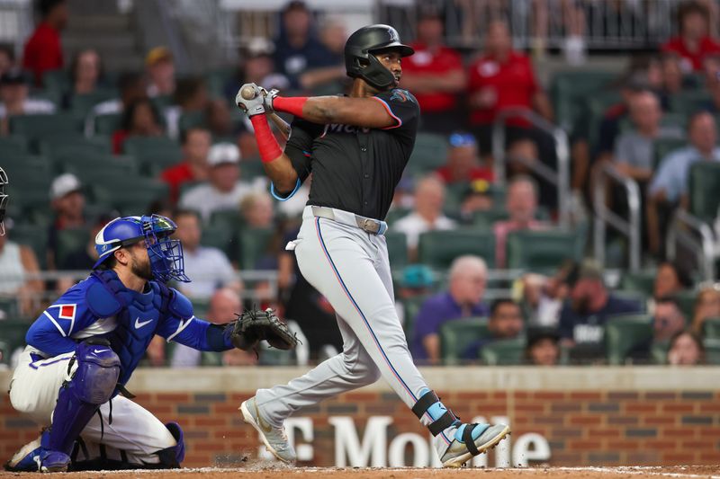 Aug 3, 2024; Atlanta, Georgia, USA; Miami Marlins right fielder Jesus Sanchez (12) hits a RBI double against the Atlanta Braves in the fifth inning at Truist Park. Mandatory Credit: Brett Davis-USA TODAY Sports