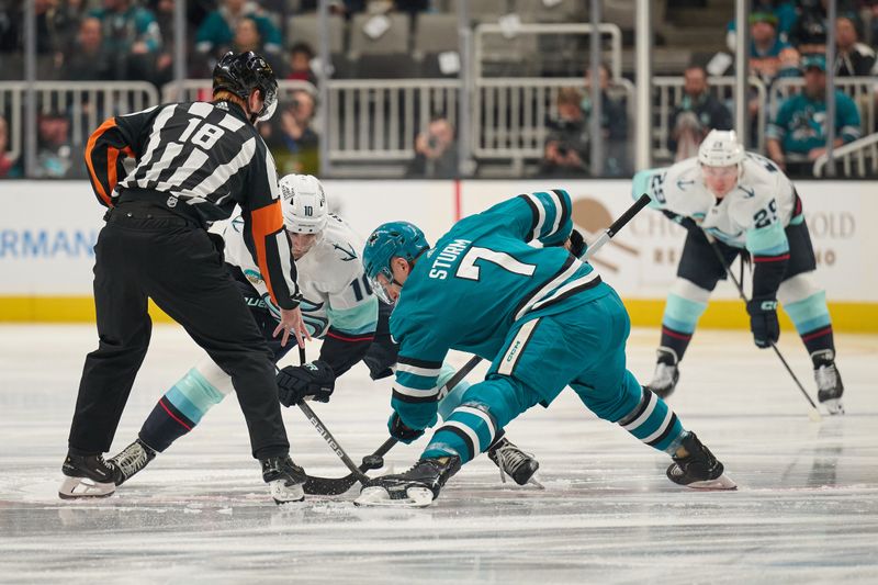 Jan 30, 2024; San Jose, California, USA; Referee Tom Chmielewski (18) drops the puck for the opening face-off between Seattle Kraken center Matty Beniers (10) and San Jose Sharks center Nico Sturm (7) during the first period at SAP Center at San Jose. Mandatory Credit: Robert Edwards-USA TODAY Sports