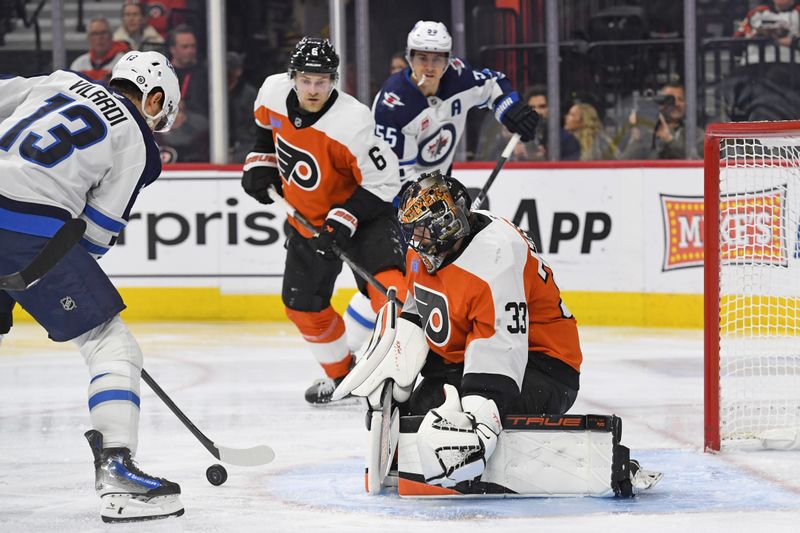 Mar 6, 2025; Philadelphia, Pennsylvania, USA; Philadelphia Flyers goaltender Samuel Ersson (33) makes a save against Winnipeg Jets center Gabriel Vilardi (13) during the second period at Wells Fargo Center. Mandatory Credit: Eric Hartline-Imagn Images