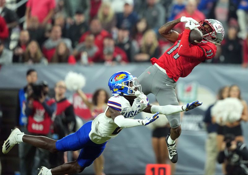 Dec 26, 2023; Phoenix, AZ, USA; UNLV Rebels wide receiver Ricky White (11) catches a touchdown pass against Kansas Jayhawks cornerback Cobee Bryant (2) during the second half at Chase Field. Mandatory Credit: Joe Camporeale-USA TODAY Sports