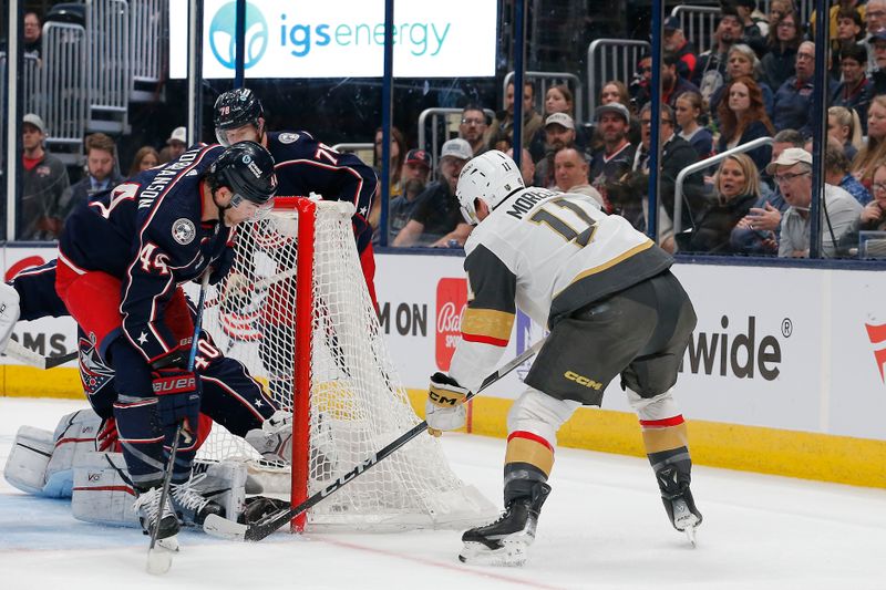 Mar 4, 2024; Columbus, Ohio, USA; Vegas Golden Knights left wing Mason Morelli (11) slides puck past Columbus Blue Jackets goalie Daniil Tarasov (40) for a goal during the first period at Nationwide Arena. Mandatory Credit: Russell LaBounty-USA TODAY Sports