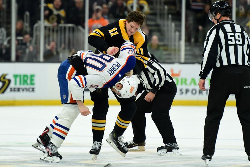 Jan 7, 2025; Boston, Massachusetts, USA;  Boston Bruins center Trent Frederic (11) fights with Edmonton Oilers right wing Corey Perry (90) during the second period at TD Garden. Mandatory Credit: Bob DeChiara-Imagn Images