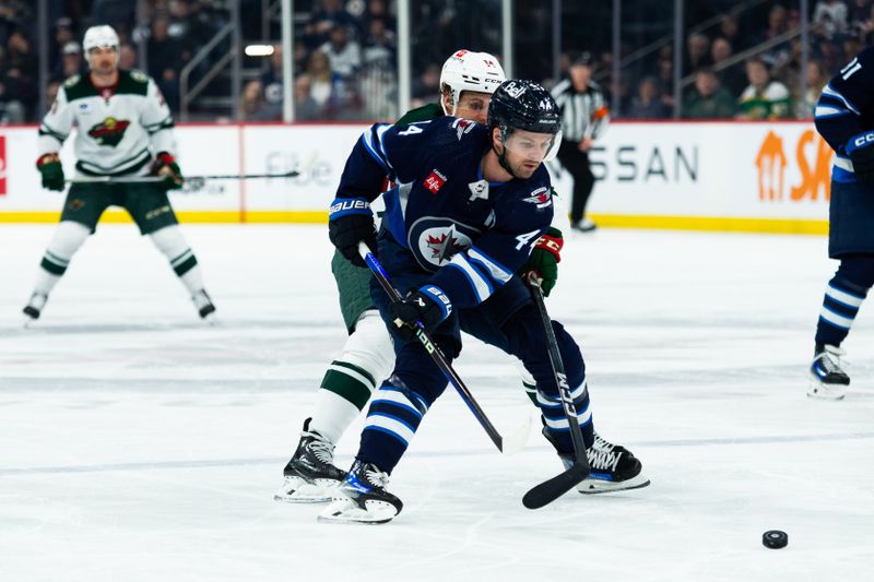 Feb 20, 2024; Winnipeg, Manitoba, CAN; Winnipeg Jets defenseman Josh Morrissey (44) skates away from Minnesota Wild forward Joel Eriksson EK (14) during first period at Canada Life Centre. Mandatory Credit: Terrence Lee-USA TODAY Sports