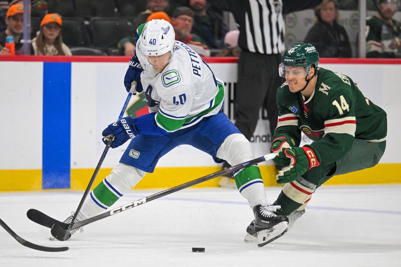 Nov 1, 2025; Saint Paul, Minnesota, USA;  Vancouver Canucks forward Elias Pettersson (40) controls the puck while Minnesota Wild forward Joel Eriksson Ek (14) defends during the third period at Grand Casino Arena. Mandatory Credit: Nick Wosika-Imagn Images