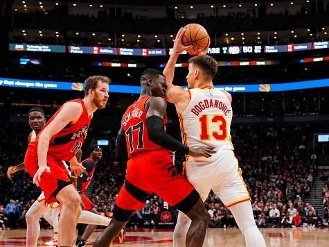 TORONTO, ON - DECEMBER 13: Dennis Schroder #17 of the Toronto Raptors is fouled by Bogdan Bogdanovic #13 of the Atlanta Hawks during first half NBA action at Scotiabank Arena on December 13, 2023 in Toronto, Ontario, Canada. NOTE TO USER: User expressly acknowledges and agrees that, by downloading and/or using this Photograph, user is consenting to the terms and conditions of the Getty Images License Agreement. (Photo by Andrew Lahodynskyj/Getty Images)