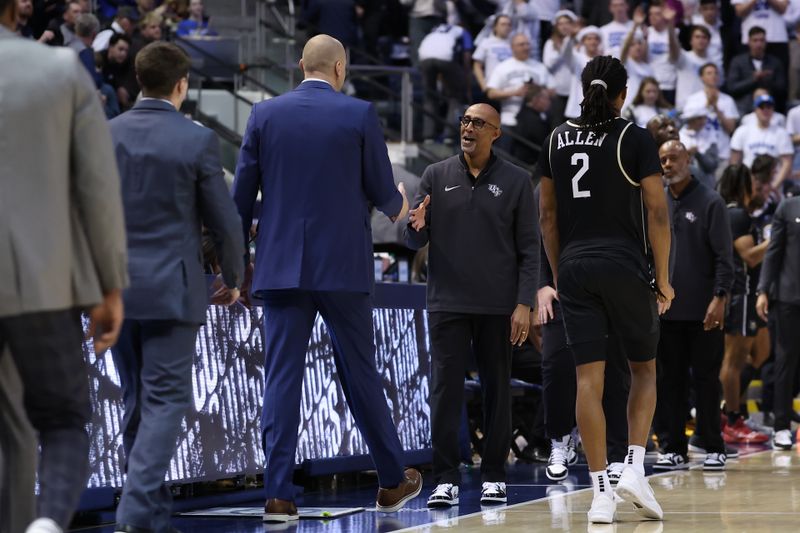 Feb 13, 2024; Provo, Utah, USA; Central Florida Knights head coach Johnny Dawkins (right) and Brigham Young Cougars head coach Mark Pope (left) shake hands after the game at Marriott Center. Mandatory Credit: Rob Gray-USA TODAY Sports