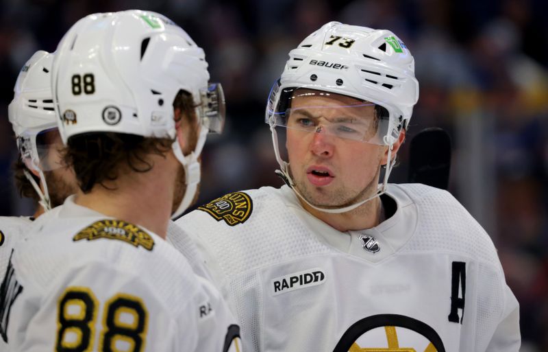 Dec 27, 2023; Buffalo, New York, USA;  Boston Bruins defenseman Charlie McAvoy (73) talks to right wing David Pastrnak (88) during a stoppage in play against the Buffalo Sabres during the third period at KeyBank Center. Mandatory Credit: Timothy T. Ludwig-USA TODAY Sports