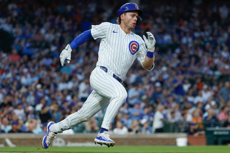 Jun 17, 2024; Chicago, Illinois, USA; Chicago Cubs second baseman Nico Hoerner (2) runs to first base after hitting a single against the San Francisco Giants during the fourth inning at Wrigley Field. Mandatory Credit: Kamil Krzaczynski-USA TODAY Sports