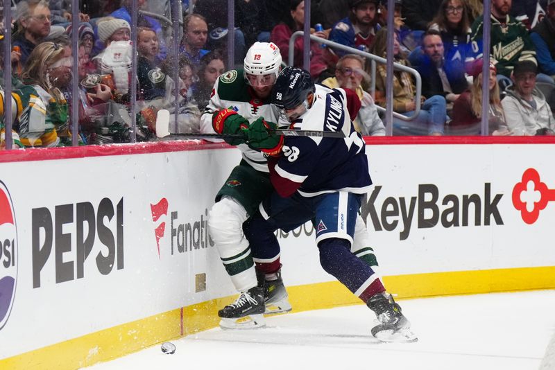 Feb 28, 2025; Denver, Colorado, USA; Colorado Avalanche defenseman Oliver Kylington (58) checks Minnesota Wild center Yakov Trenin (13) in the third period at Ball Arena. Mandatory Credit: Ron Chenoy-Imagn Images