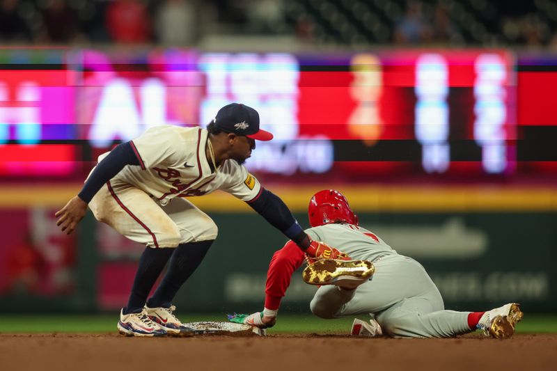 Apr 10, 2025; Atlanta, Georgia, USA; Philadelphia Phillies first baseman Bryce Harper (3) steals a base past Atlanta Braves second baseman Ozzie Albies (1) in the eighth inning at Truist Park. Mandatory Credit: Brett Davis-Imagn Images