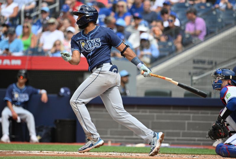 Jul 25, 2024; Toronto, Ontario, CAN; Tampa Bay Rays third baseman Ahmed Rosario (10) hits a single against the Toronto Blue Jays in the second inning at Rogers Centre. Mandatory Credit: Dan Hamilton-USA TODAY Sports