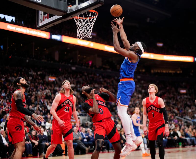 TORONTO, ON - MARCH 27: Precious Achiuwa #5 of the New York Knicks shoots against Gradey Dick #1, Javon Freeman-Liberty #0, Kelly Olynyk #41, and Gary Trent Jr. #33 of the Toronto Raptors during the first half of their basketball game at the Scotiabank Arena on March 27, 2024 in Toronto, Ontario, Canada. NOTE TO USER: User expressly acknowledges and agrees that, by downloading and/or using this Photograph, user is consenting to the terms and conditions of the Getty Images License Agreement. (Photo by Mark Blinch/Getty Images)