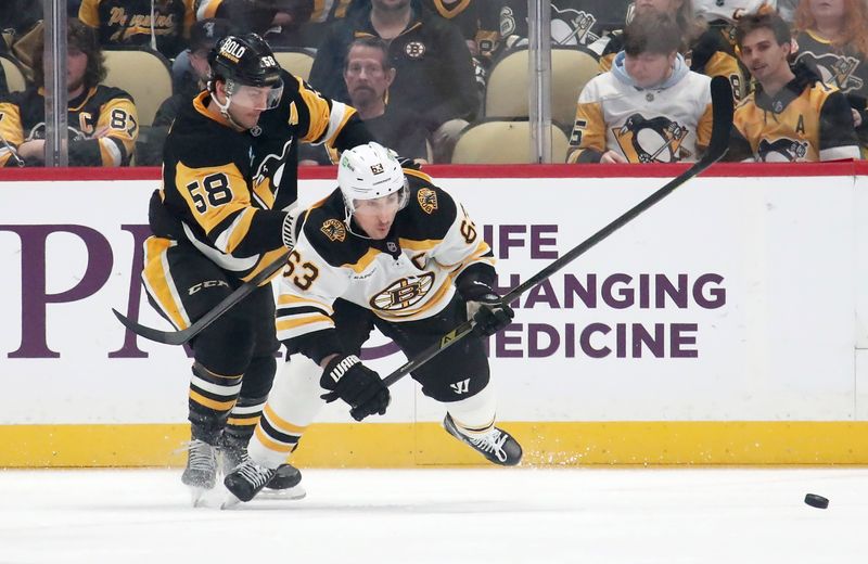 Mar 1, 2025; Pittsburgh, Pennsylvania, USA;  Pittsburgh Penguins defenseman Kris Letang (58) checks Boston Bruins left wing Brad Marchand (63) during the first period at PPG Paints Arena. Mandatory Credit: Charles LeClaire-Imagn Images