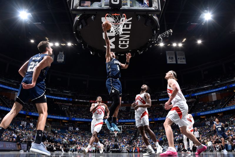 ORLANDO, FL - MARCH 17: Paolo Banchero #5 of the Orlando Magic drives to the basket during the game against the Toronto Raptors on March 17, 2024 at the Kia Center in Orlando, Florida. NOTE TO USER: User expressly acknowledges and agrees that, by downloading and or using this photograph, User is consenting to the terms and conditions of the Getty Images License Agreement. Mandatory Copyright Notice: Copyright 2024 NBAE (Photo by Fernando Medina/NBAE via Getty Images)