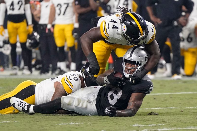 Las Vegas Raiders running back Josh Jacobs, lower right, is tackled by Pittsburgh Steelers linebacker Elandon Roberts, left, and linebacker Markus Golden during an NFL football game Sunday, Sept. 24, 2023, in Las Vegas. (AP Photo/Mark J. Terrill)