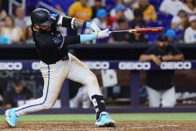 Apr 12, 2024; Miami, Florida, USA; Miami Marlins third baseman Emmanuel Rivera (15) hits an RBI single against the Atlanta Braves during the seventh inning at loanDepot Park. Mandatory Credit: Sam Navarro-USA TODAY Sports