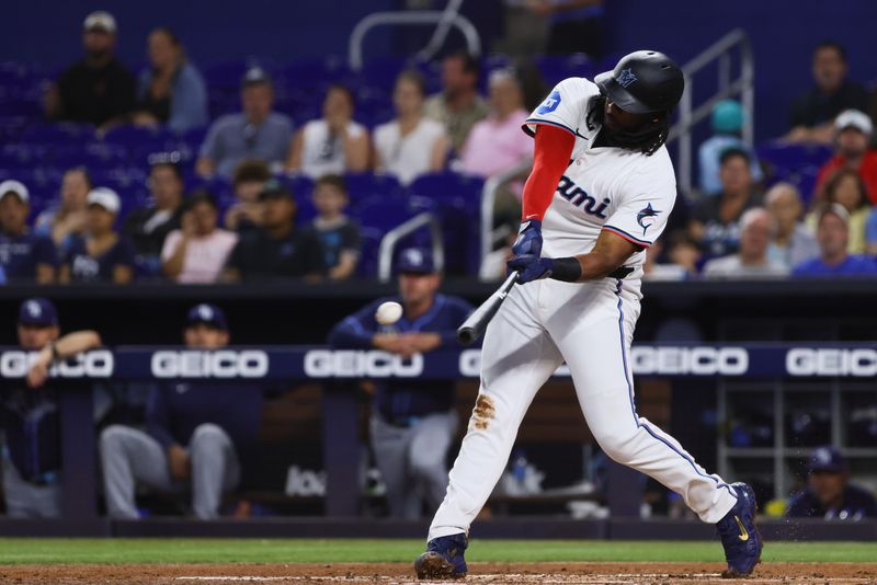 Jun 5, 2024; Miami, Florida, USA; Miami Marlins first baseman Josh Bell (9) hits a single against the Tampa Bay Rays during the first inning at loanDepot Park. Mandatory Credit: Sam Navarro-USA TODAY Sports