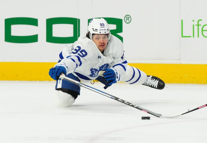 Mar 24, 2024; Raleigh, North Carolina, USA;  Toronto Maple Leafs left wing Nicholas Robertson (89) dives to poke the puck away from a Carolina Hurricanes player during the first period at PNC Arena. Mandatory Credit: James Guillory-USA TODAY Sports