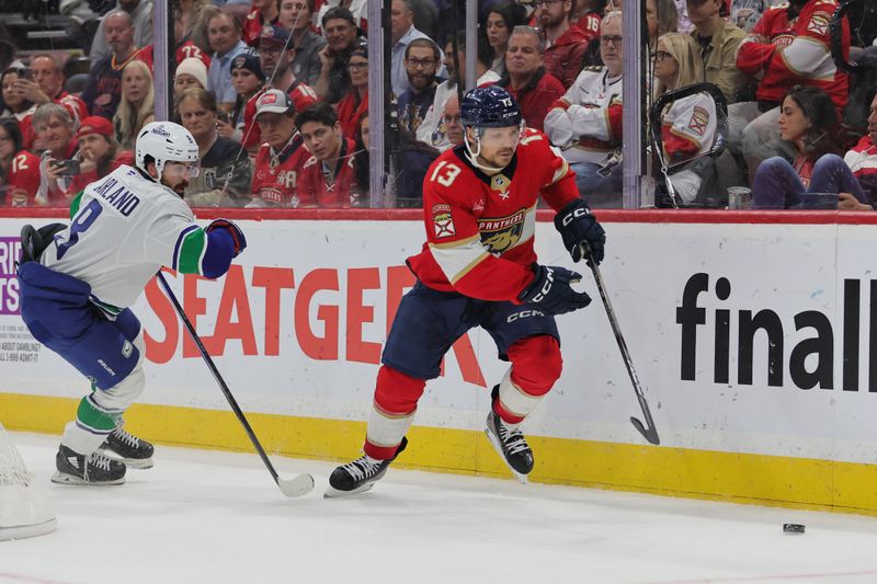 Oct 17, 2024; Sunrise, Florida, USA; Florida Panthers center Sam Reinhart (13) moves the puck past Vancouver Canucks right wing Conor Garland (8) during the third period at Amerant Bank Arena. Mandatory Credit: Sam Navarro-Imagn Images