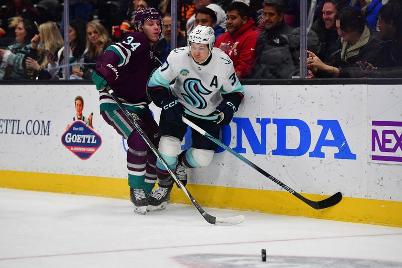 Dec 23, 2023; Anaheim, California, USA; Anaheim Ducks defenseman Pavel Mintyukov (34) plays for the puck against Seattle Kraken center Yanni Gourde (37) during the first period at Honda Center. Mandatory Credit: Gary A. Vasquez-USA TODAY Sports