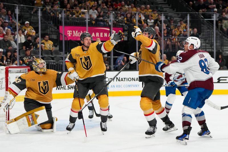 Oct 9, 2024; Las Vegas, Nevada, USA; Vegas Golden Knights defenseman Nicolas Hague (14) and center Tomas Hertl (48) reach for the puck during the third period against the Colorado Avalanche at T-Mobile Arena. Mandatory Credit: Lucas Peltier-Imagn Images
