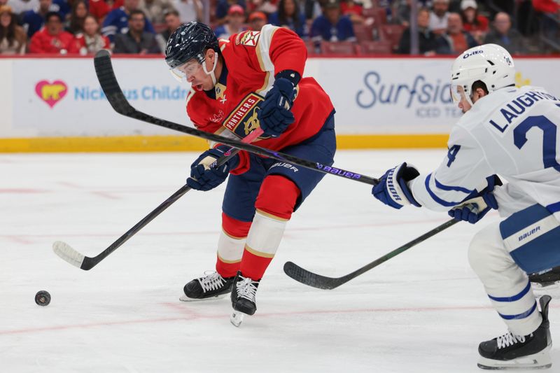 Feb 26, 2026; Sunrise, Florida, USA; Florida Panthers center Evan Rodrigues (17) moves the puck against Toronto Maple Leafs defenseman Brandon Carlo (25) during the first period at Amerant Bank Arena. Mandatory Credit: Sam Navarro-Imagn Images
