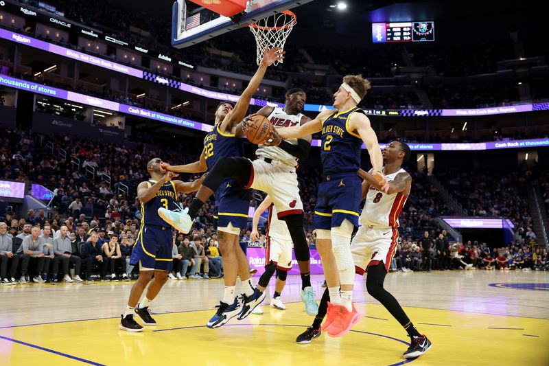 SAN FRANCISCO, CALIFORNIA - DECEMBER 28: Bam Adebayo #13 of the Miami Heat goes up for a rebound against Trayce Jackson-Davis #32 and Brandin Podziemski #2 of the Golden State Warriors in the second half at Chase Center on December 28, 2023 in San Francisco, California. NOTE TO USER: User expressly acknowledges and agrees that, by downloading and or using this photograph, User is consenting to the terms and conditions of the Getty Images License Agreement.  (Photo by Ezra Shaw/Getty Images)