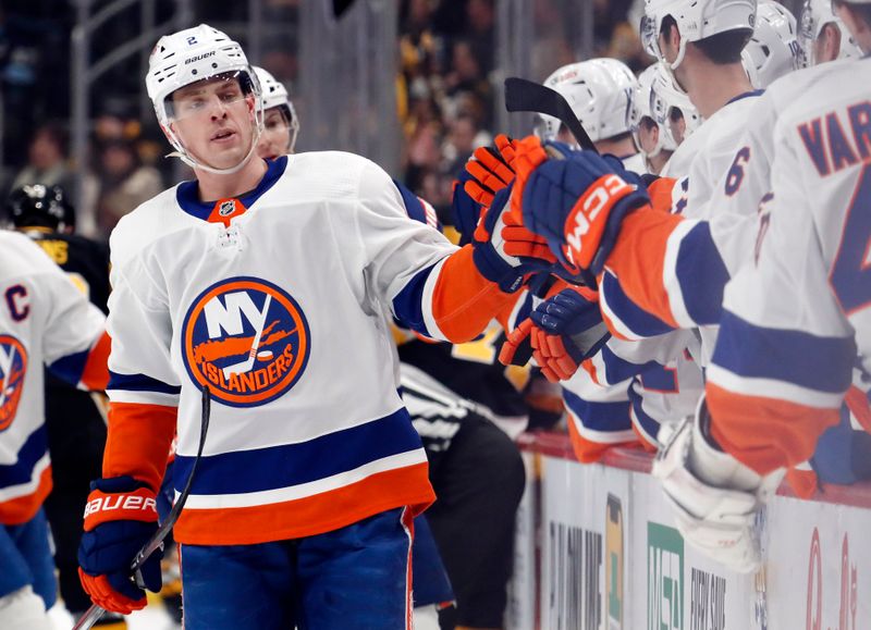 Feb 20, 2024; Pittsburgh, Pennsylvania, USA; New York Islanders defenseman Mike Reilly (2) celebrates with the Islanders bench after scoring a goal against the Pittsburgh Penguins during the third period at PPG Paints Arena. New York won 5-4 in overtime. Mandatory Credit: Charles LeClaire-USA TODAY Sports