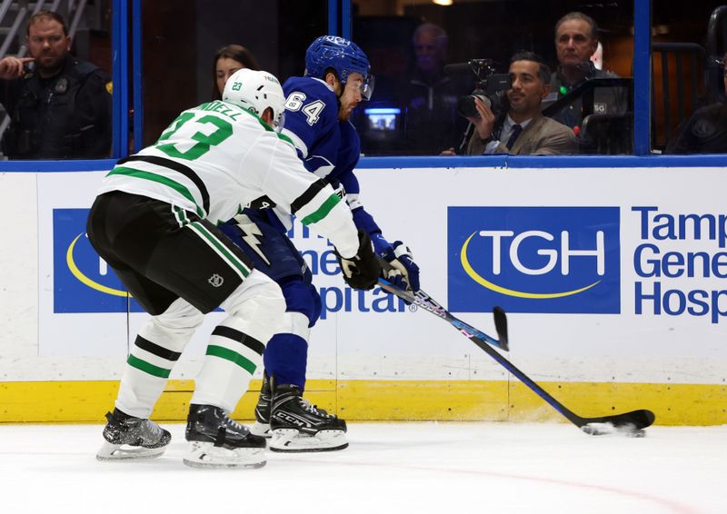 Dec 4, 2023; Tampa, Florida, USA; Tampa Bay Lightning center Tyler Motte (64) skates with the puck as Dallas Stars defenseman Esa Lindell (23) defends during the first period at Amalie Arena. Mandatory Credit: Kim Klement Neitzel-USA TODAY Sports