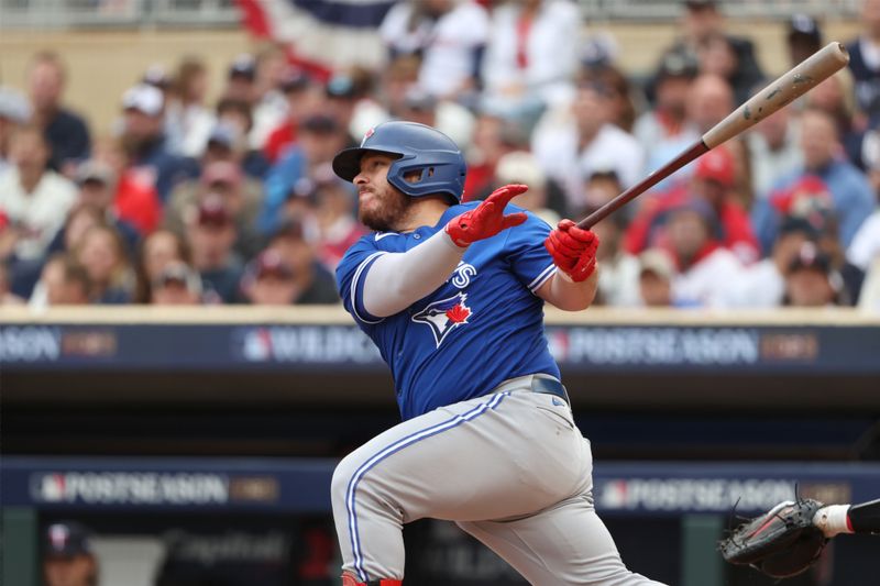 Oct 4, 2023; Minneapolis, Minnesota, USA; Toronto Blue Jays catcher Alejandro Kirk (30) hits a single in the second inning against the Minnesota Twins during game two of the Wildcard series for the 2023 MLB playoffs at Target Field. Mandatory Credit: Jesse Johnson-USA TODAY Sports