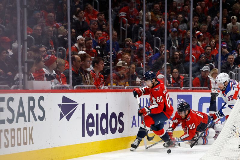 Jan 4, 2025; Washington, District of Columbia, USA; Washington Capitals left wing Andrew Mangiapane (88) and New York Rangers defenseman Ryan Lindgren (55) battle for the puck in the third period at Capital One Arena. Mandatory Credit: Geoff Burke-Imagn Images