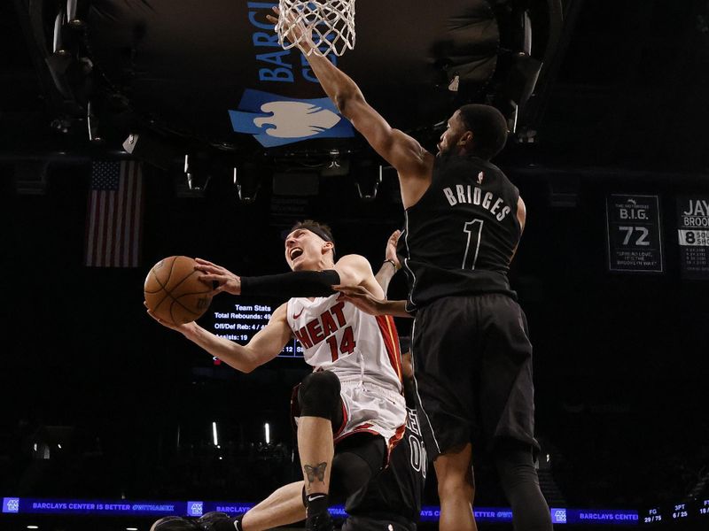 NEW YORK, NEW YORK - JANUARY 15:  Tyler Herro #14 of the Miami Heat shoots against Mikal Bridges #1 of the Brooklyn Nets during their game at Barclays Center on January 15, 2024 in New York City.   User expressly acknowledges and agrees that, by downloading and or using this photograph, User is consenting to the terms and conditions of the Getty Images License Agreement.  (Photo by Al Bello/Getty Images)