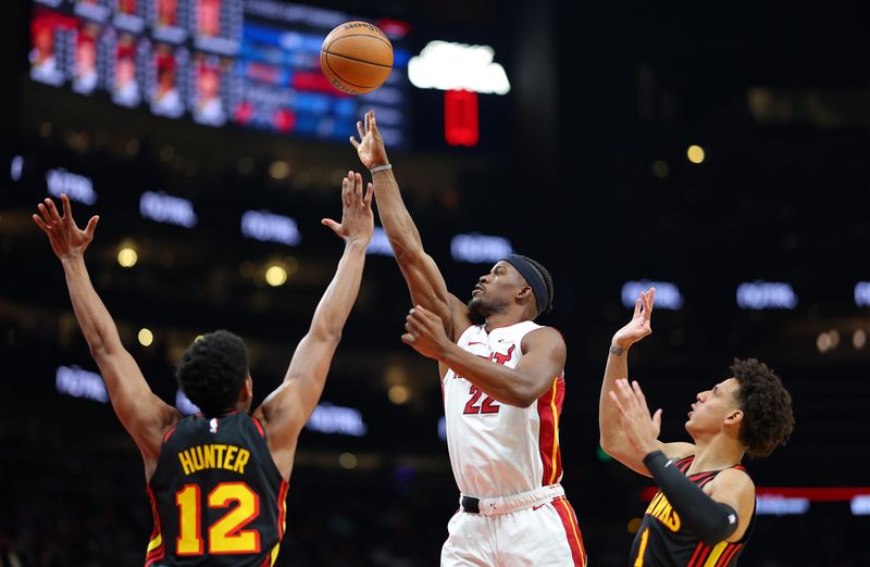 ATLANTA, GEORGIA - APRIL 09:  Jimmy Butler #22 of the Miami Heat attempts a shot against De'Andre Hunter #12 and Jalen Johnson #1 of the Atlanta Hawks during the first quarter at State Farm Arena on April 09, 2024 in Atlanta, Georgia.  NOTE TO USER: User expressly acknowledges and agrees that, by downloading and/or using this photograph, user is consenting to the terms and conditions of the Getty Images License Agreement.  (Photo by Kevin C. Cox/Getty Images)