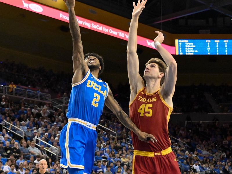 Feb 24, 2026; Los Angeles, California, USA; UCLA Bruins guard Donovan Dent (2) drives to the basket past Southern California Trojans center Gabe Dynes (45) during the second half at Pauley Pavilion presented by Wescom Financial. Mandatory Credit: Robert Hanashiro-Imagn Images