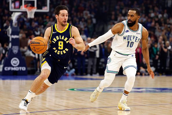 MINNEAPOLIS, MINNESOTA - DECEMBER 16: T.J. McConnell #9 of the Indiana Pacers drives to the basket while Mike Conley #10 of the Minnesota Timberwolves defends in the first quarter at Target Center on December 16, 2023 in Minneapolis, Minnesota. NOTE TO USER: User expressly acknowledges and agrees that, by downloading and or using this photograph, User is consenting to the terms and conditions of the Getty Images License Agreement. (Photo by David Berding/Getty Images)