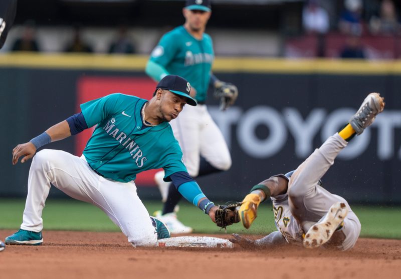 May 11, 2024; Seattle, Washington, USA; Seattle Mariners second baseman Jorge Polanco (7) attempts to tag out Oakland Athletics right fielder Lawrence Butler (4) as Butler steals second base during the fourth inning at T-Mobile Park. Mandatory Credit: Stephen Brashear-USA TODAY Sports