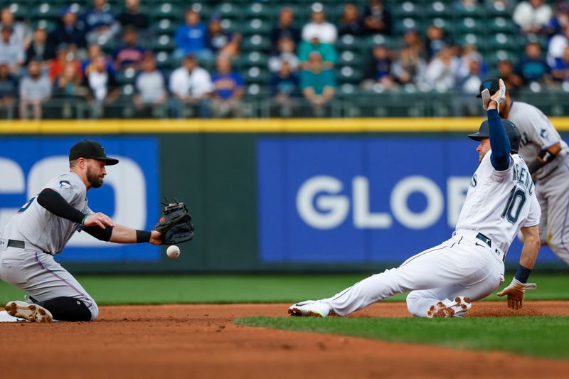 Jun 13, 2023; Seattle, Washington, USA; Seattle Mariners left fielder Jarred Kelenic (10) steals second base as Miami Marlins shortstop Jon Berti (5) attempts to field a throw during the fourth inning at T-Mobile Park. Mandatory Credit: Joe Nicholson-USA TODAY Sports