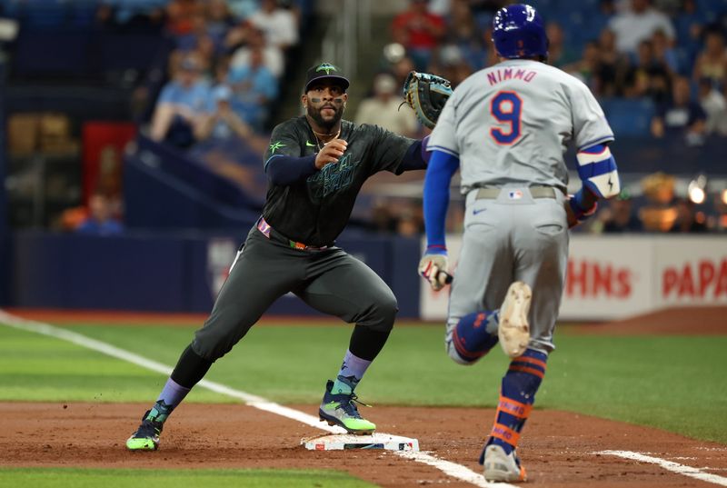 May 4, 2024; St. Petersburg, Florida, USA; Tampa Bay Rays first base Yandy Diaz (2) forces out New York Mets outfielder Brandon Nimmo (9) during the third inning at Tropicana Field. Mandatory Credit: Kim Klement Neitzel-USA TODAY Sports