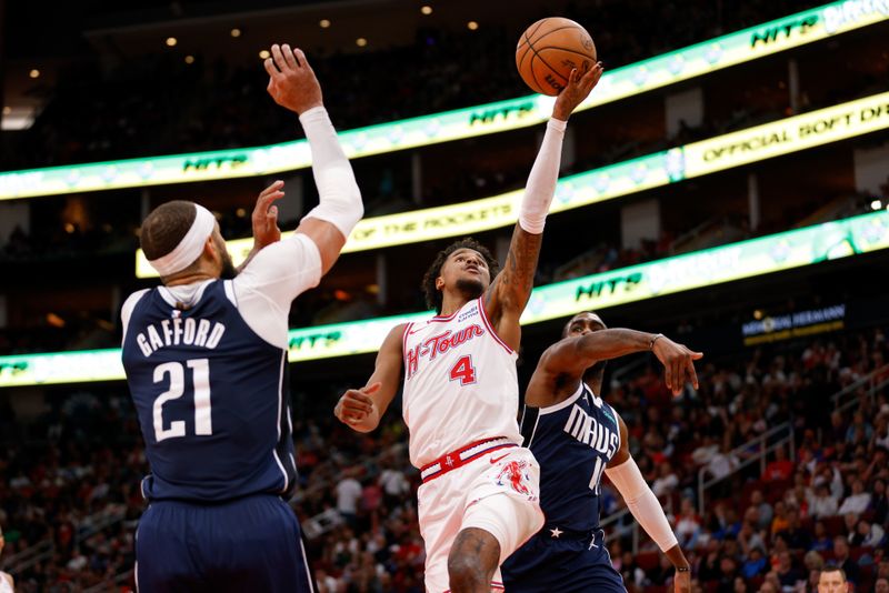 HOUSTON, TEXAS - MARCH 31: Jalen Green #4 of the Houston Rockets drives to the basket while defended by Tim Hardaway Jr. #10 of the Dallas Mavericks and Daniel Gafford #21 in the second half at Toyota Center on March 31, 2024 in Houston, Texas.  NOTE TO USER: User expressly acknowledges and agrees that, by downloading and or using this photograph, User is consenting to the terms and conditions of the Getty Images License Agreement. (Photo by Tim Warner/Getty Images)