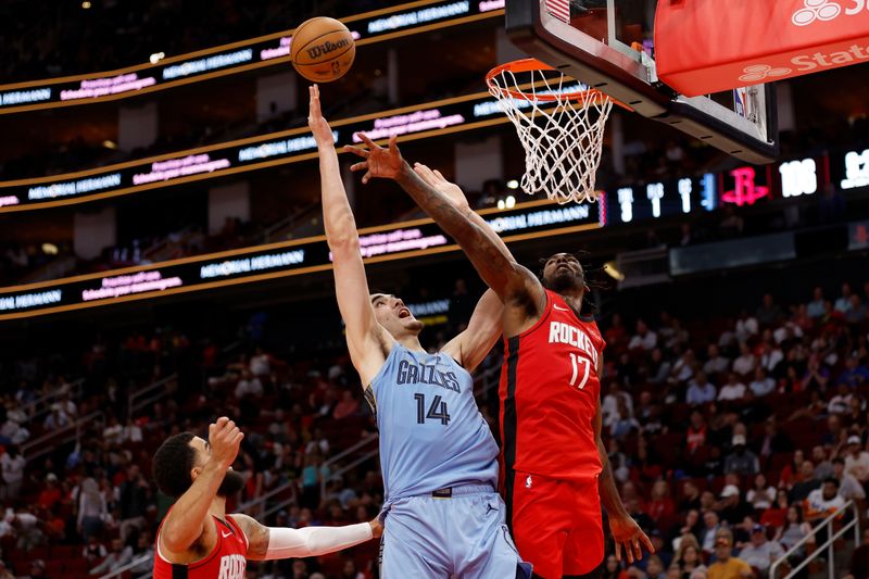 HOUSTON, TEXAS - OCTOBER 25: Tari Eason #17 of the Houston Rockets defends a shot by Zach Edey #14 of the Memphis Grizzlies in the second half at Toyota Center on October 25, 2024 in Houston, Texas.  NOTE TO USER: User expressly acknowledges and agrees that, by downloading and or using this photograph, User is consenting to the terms and conditions of the Getty Images License Agreement.  (Photo by Tim Warner/Getty Images)