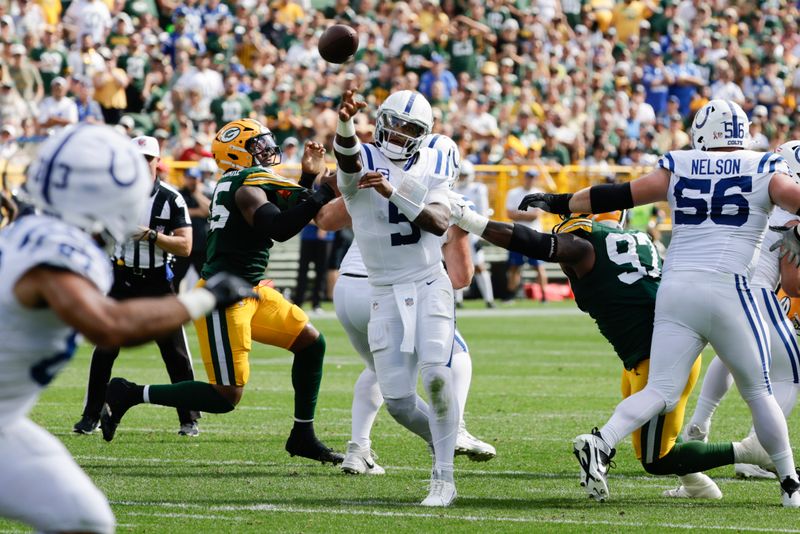 Indianapolis Colts quarterback Anthony Richardson (5) throws under pressure from Green Bay Packers defensive tackle Kenny Clark (97) during the second half of an NFL football game Sunday, Sept. 15, 2024, in Green Bay, Wis. (AP Photo/Mike Roemer)