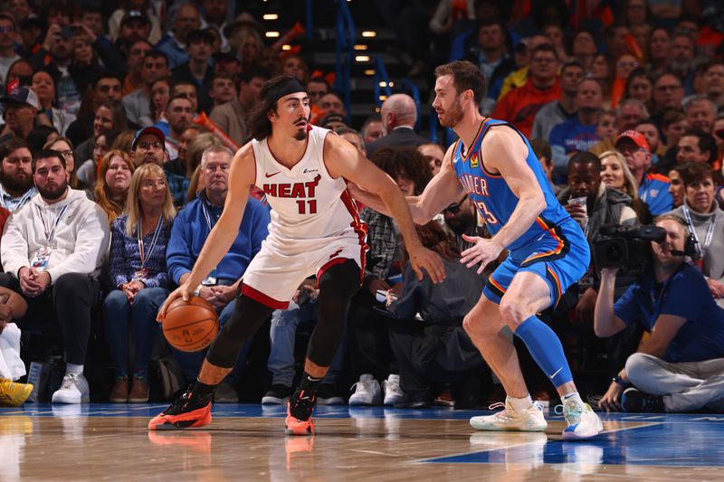 OKLAHOMA CITY, OK - MARCH 8:  Jaime Jaquez Jr. #11 of the Miami Heat handles the ball during the game as Gordon Hayward #33 of the Oklahoma City Thunder plays defense on March 8, 2024 at Paycom Arena in Oklahoma City, Oklahoma. NOTE TO USER: User expressly acknowledges and agrees that, by downloading and or using this photograph, User is consenting to the terms and conditions of the Getty Images License Agreement. Mandatory Copyright Notice: Copyright 2024 NBAE (Photo by Zach Beeker/NBAE via Getty Images)